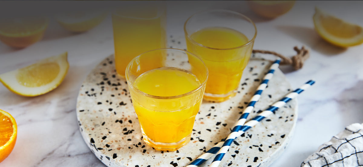 Verres de jus d'agrumes frais préparés avec le Presse-Agrumes du Juice Expert
