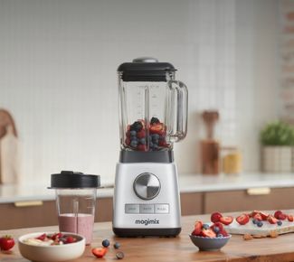 Blender Magimix rempli d'un smoothie vert sain avec tartines et bol sur plan de travail en bois