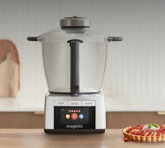 Robot cuiseur Magimix Cook Expert avec écran tactile allumé à côté d'une brioche maison dorée